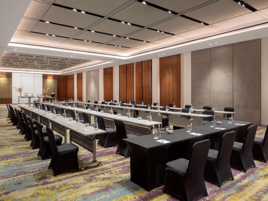 a large conference room with long tables and chairs at Radisson Lampung Kedaton in Bandar Lampung