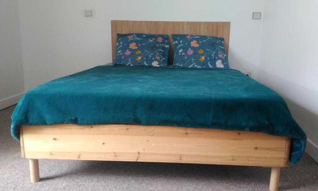 Una cama con una manta azul encima. en Maison en Location Fresnes sur Marne, en Fresnes-sur-Marne
