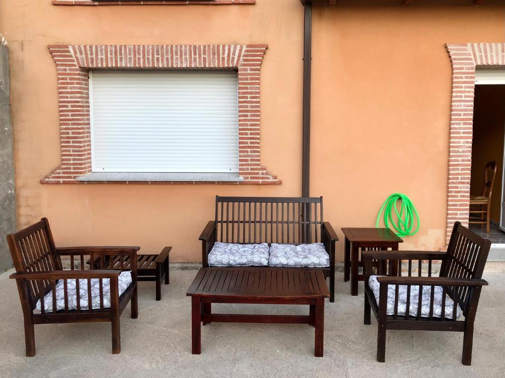 un grupo de sillas y un banco frente a un edificio en VUT LA TABERNA I, en Poyales del Hoyo