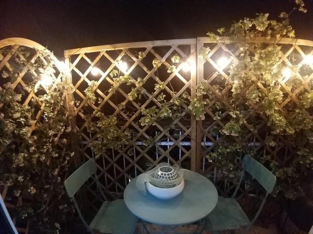 una mesa y sillas frente a una valla por la noche en Le stanze di Mina, en Cassina deʼ Pecchi