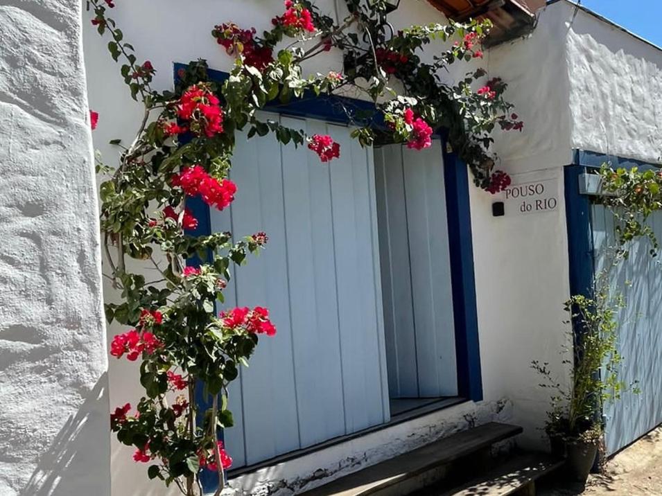 una puerta con flores al lado de un edificio en Pouso do Rio, en Pirenópolis