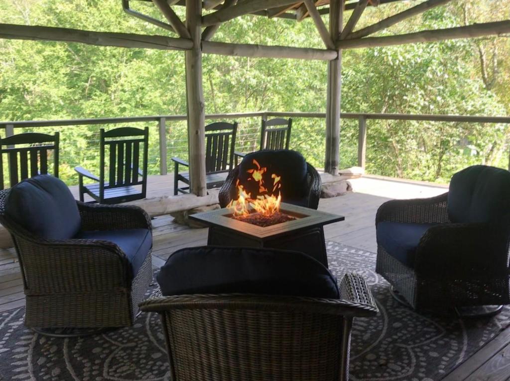 a screened in porch with chairs and a fire pit at The Blue House On The Hill Catskills—Views in Claryville