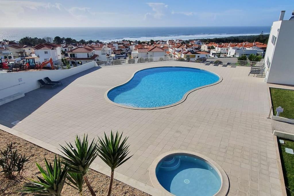 een groot zwembad op een patio van een huis bij Brisa do Mar Ap. in Nazaré