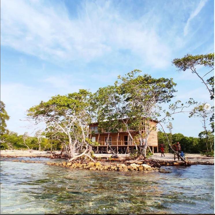 a house on a small island in the water at Hostel villa luz Beach in Tintipan Island