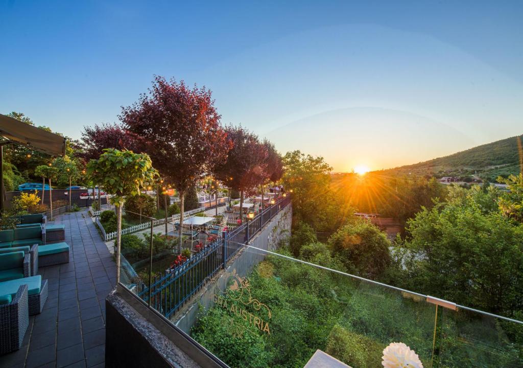 a view of a balcony with the sunset in the background at Magra Austria Hotel & Restaurant Prishtine in Prishtinë