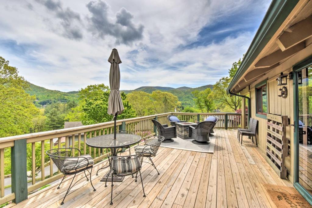 een terras met tafels en stoelen en een parasol bij Serene Sky Valley Home with 180 Degree Mountain View in Sky Valley