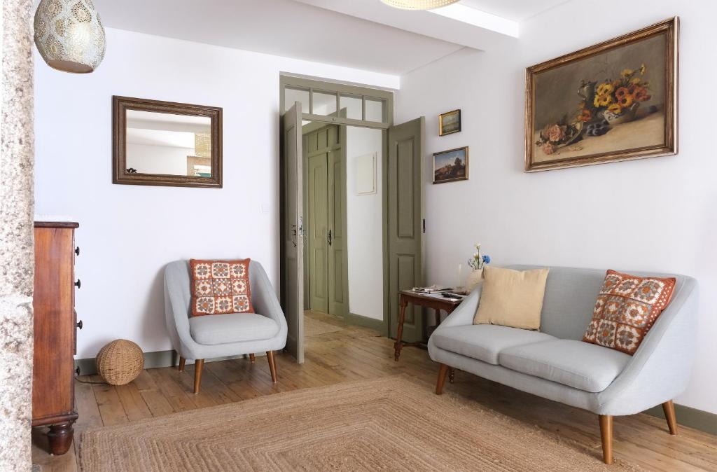 a living room with two chairs and a table at Casa da Praça - Guest House in Pinhel