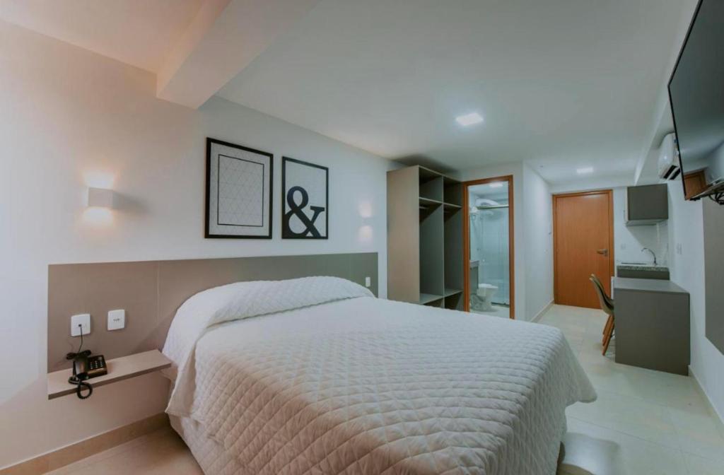 1 dormitorio con 1 cama grande y baño en Manaíra Apart Hotel, en João Pessoa