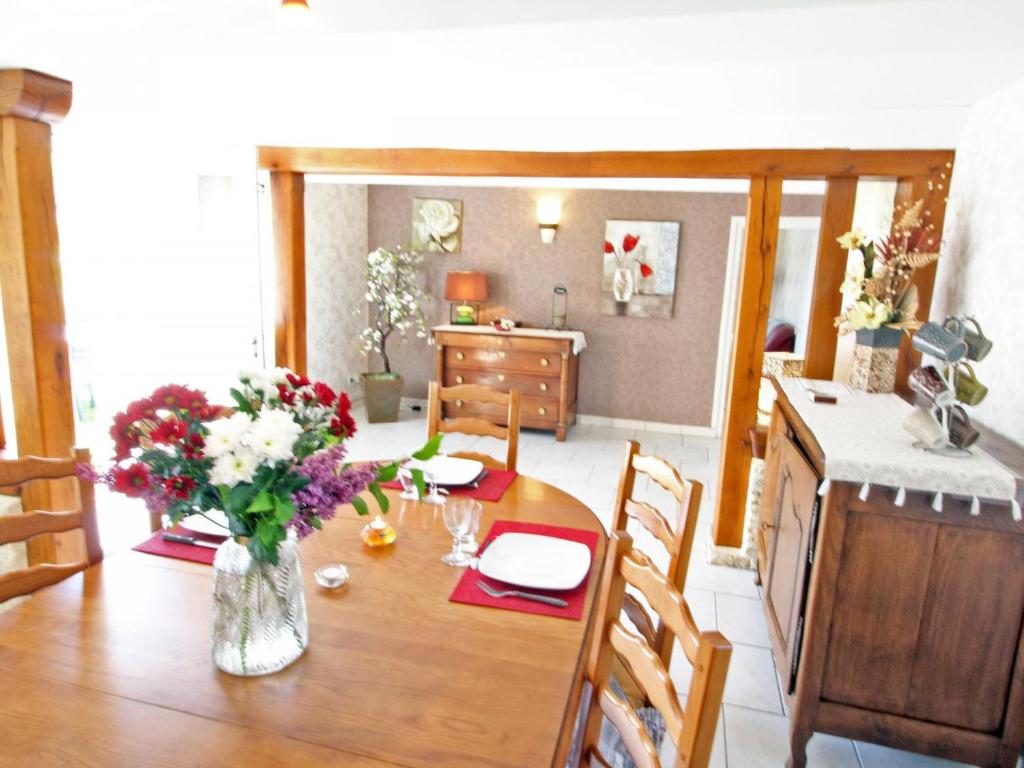 a dining room table with a vase of flowers on it at Gîte Champosoult, 5 pièces, 6 personnes - FR-1-497-27 in Champosoult