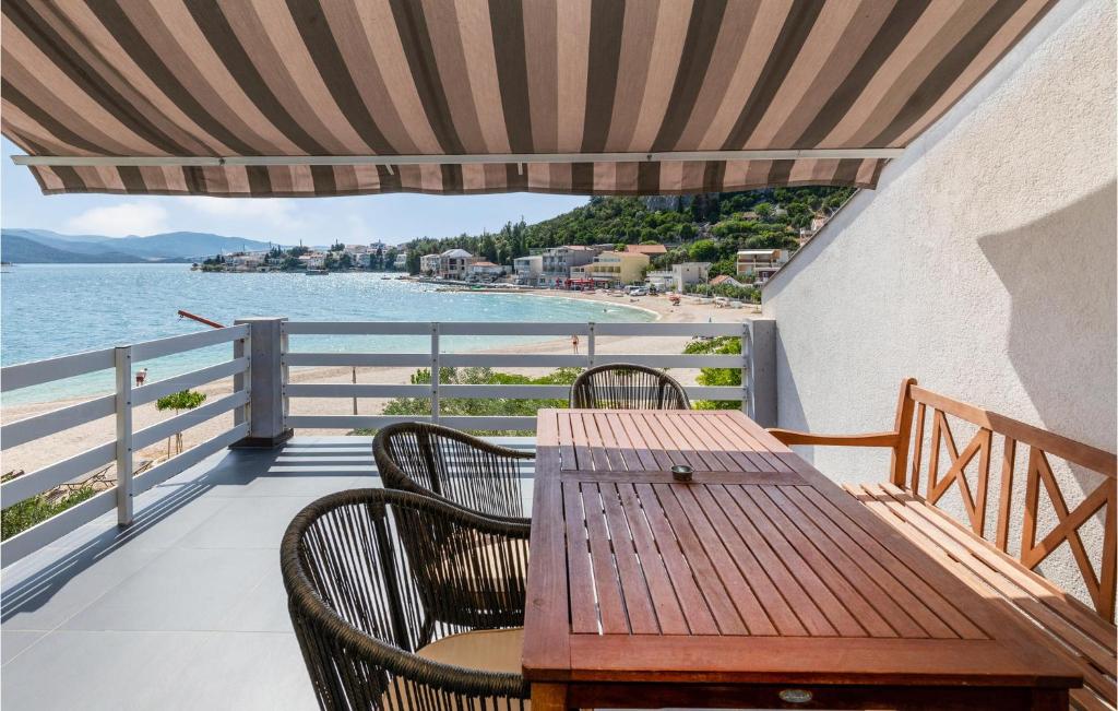 einen Tisch und Stühle auf einem Balkon mit Blick auf den Strand in der Unterkunft 3 Bedroom Awesome Apartment In Klek in Klek