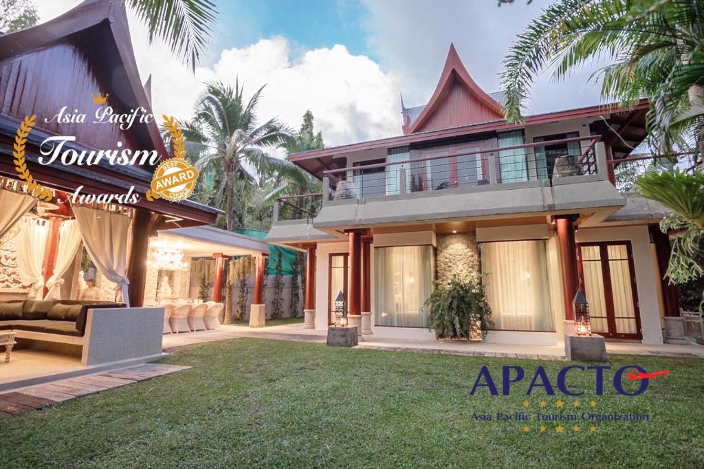 a house with a lawn in front of it at Villa in the Park, Whole house's suitable for family's vacation in Phuket