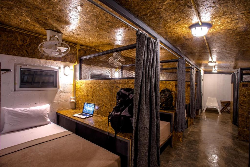 Camera con letto e scrivania con computer portatile. di Loft Hostel Koh Tao a Ko Tao