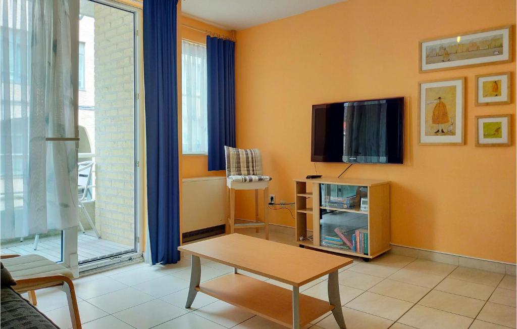 een woonkamer met een tv en een tafel bij Amazing Apartment In Oostende With Wifi in Oostende