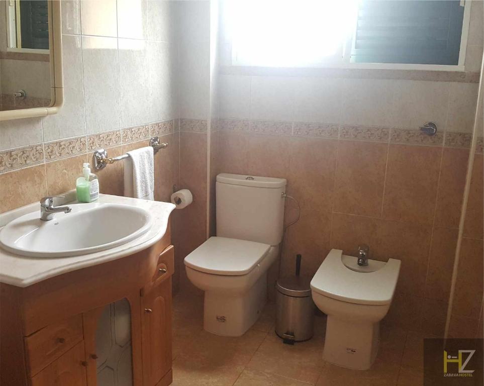 uma casa de banho com um lavatório e um WC em Hostel Zabava em Odivelas