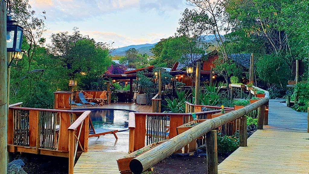 a resort with a pool and a wooden walkway at Lodge Roche Tamarin in La Possession
