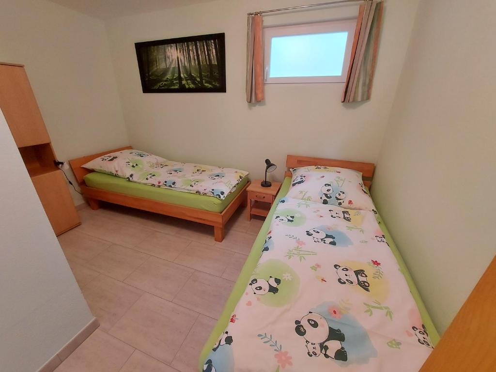 Weisbrunn的住宿－Ferienwohnung Sonne 11，一间卧室设有两张床和窗户。