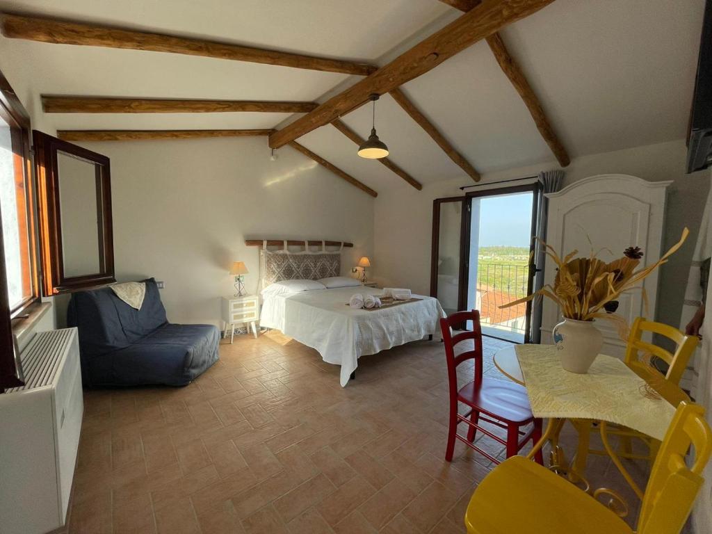Schlafzimmer mit einem Bett, einem Tisch und Stühlen in der Unterkunft Panoramic Loft con uso cucina,Casa Placida - Ammentos in Posada