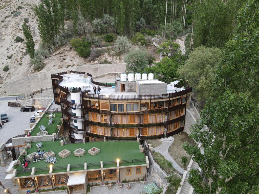 a large building with a green lawn in front of it at Famree Resort Hunza in Hunza Valley