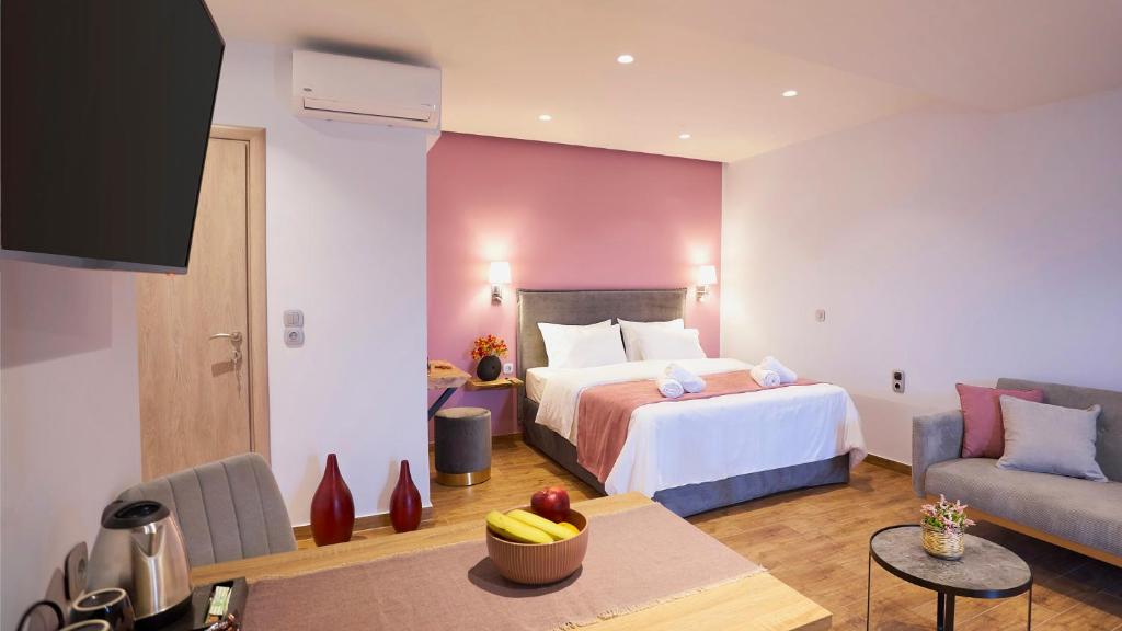 Habitación de hotel con cama y sofá en Apartments Gonies - Afroditi, en Goníai
