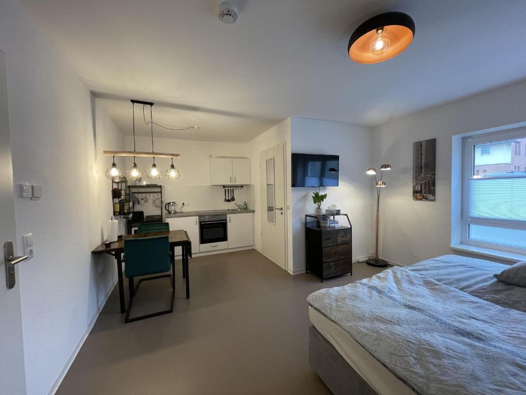 a bedroom with a bed and a desk and a kitchen at Hafenstraße Kassel in Kassel