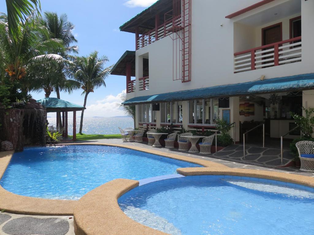 a swimming pool in front of a building at Badladz Beach and Dive Resort in Puerto Galera