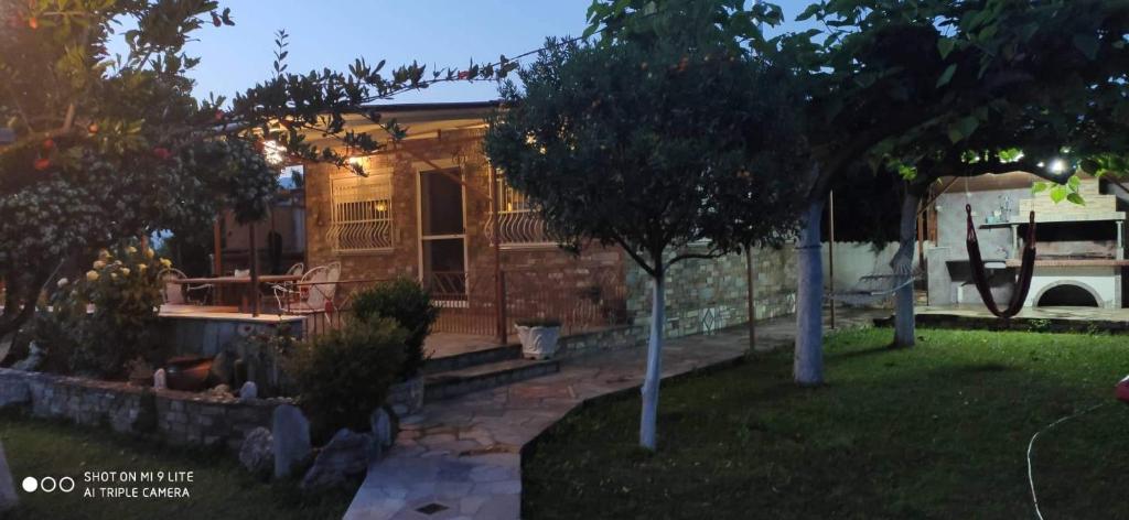una casa con un árbol en el patio en Angeliki's House en Volos