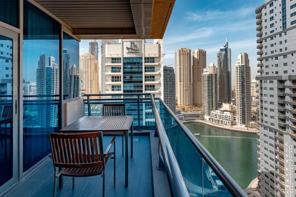 balcón con mesa, sillas y vistas a la ciudad en Radisson Blu Residence, Dubai Marina, en Dubái