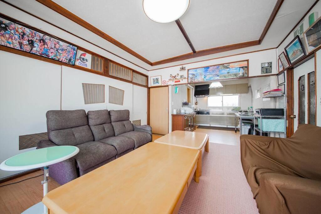 a living room with a couch and a table at GUESTHOUSE CHIYOGAOKA in Asahikawa