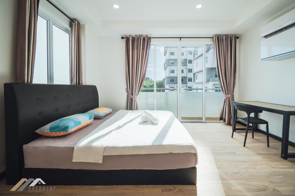 um quarto com uma cama, uma secretária e uma janela em Serene Heights by Evernent em Miri