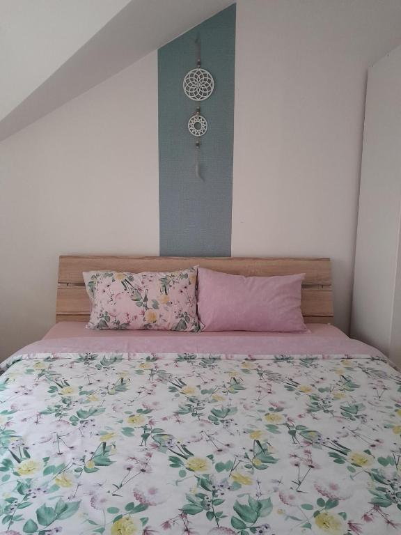 a bed with a floral bedspread and two pillows at Apartment Ken in Surčin
