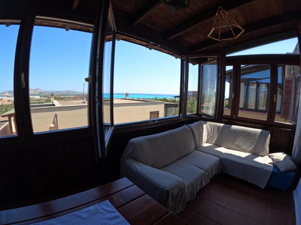 a living room with a couch and some windows at Casa La Pelosa in Stintino