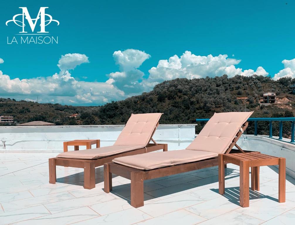 een paar ligstoelen op een patio bij LA MAISON - Sea Appartment & Petit Chalet en Bois for 4 SEASONS in Golem
