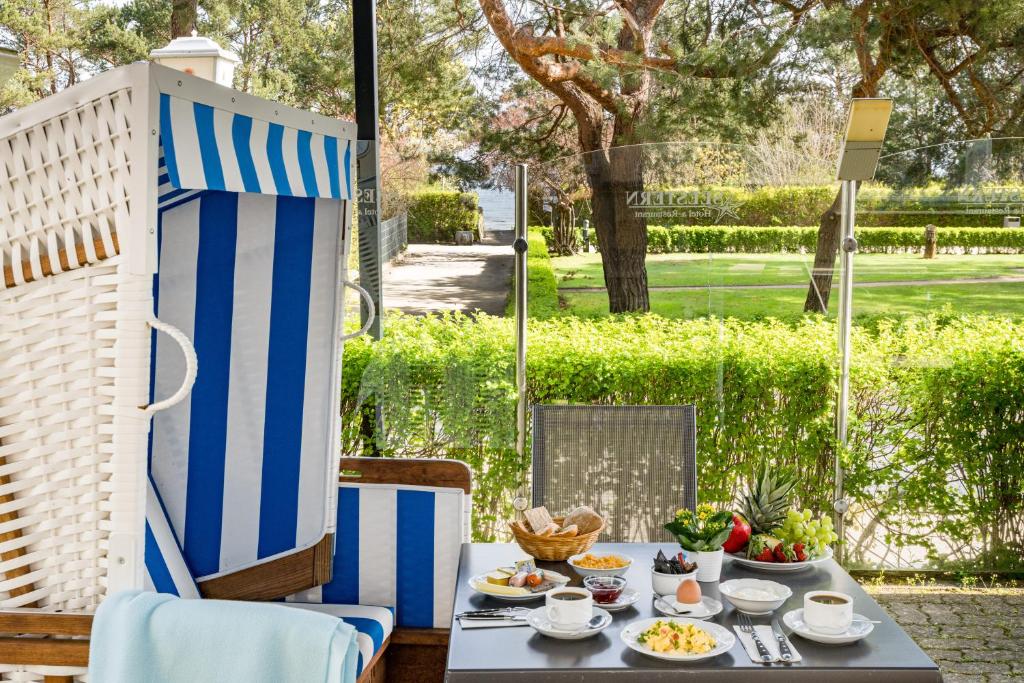 - une table avec des assiettes de nourriture sur une terrasse dans l'établissement Hotel Seestern, à Zinnowitz