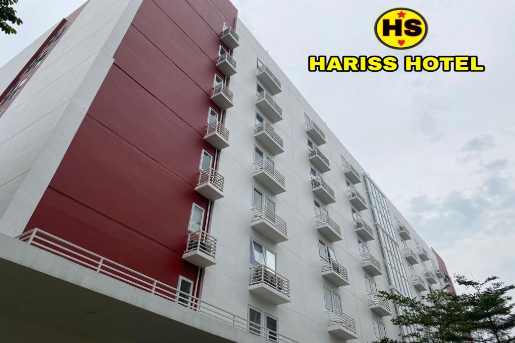 ein hohes Gebäude mit einem Hotelschild drauf in der Unterkunft Hariss Inn Bandara in Teko