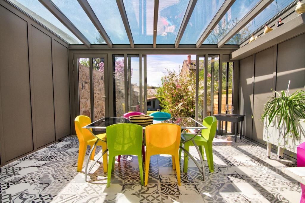 a conservatory with a table and chairs on a patio at Le Pop in Saint-Julien-Chapteuil