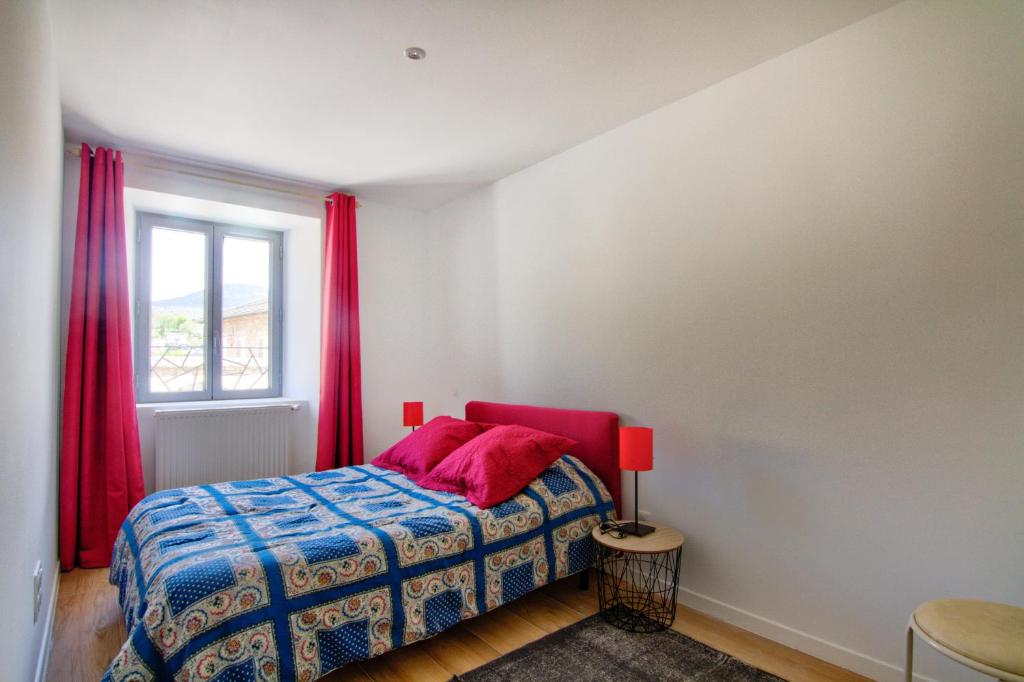 a bedroom with a bed with red curtains and a window at Le Pop in Saint-Julien-Chapteuil