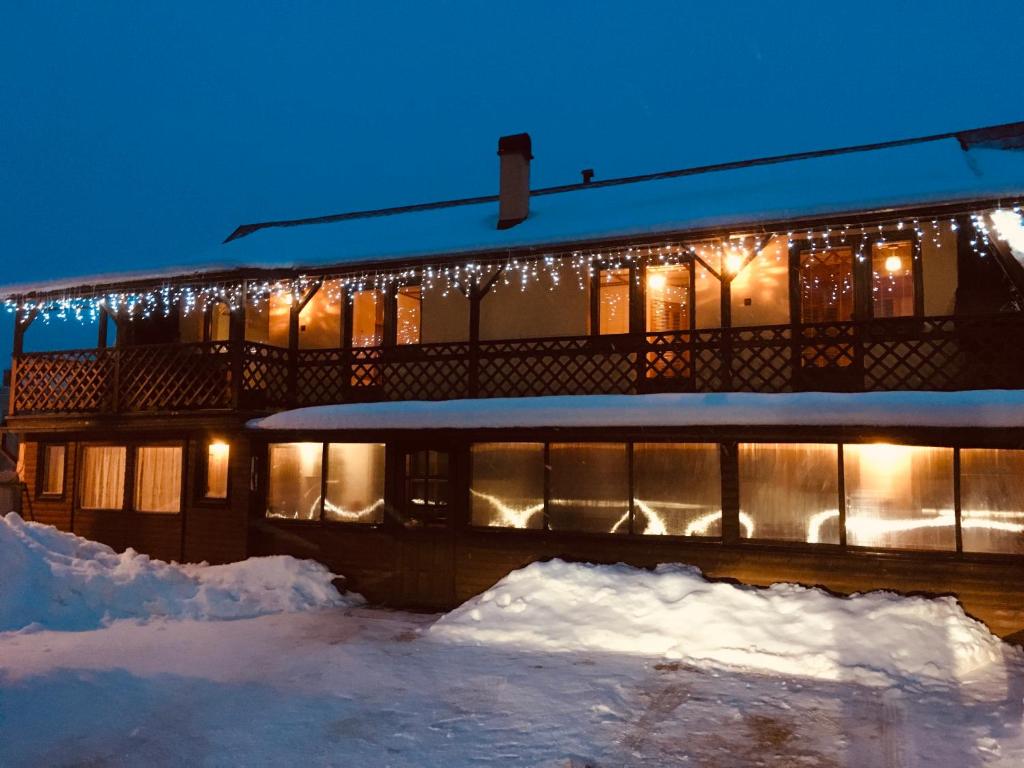 a building covered in snow at night with lights at Penzión Pohoda in Zuberec