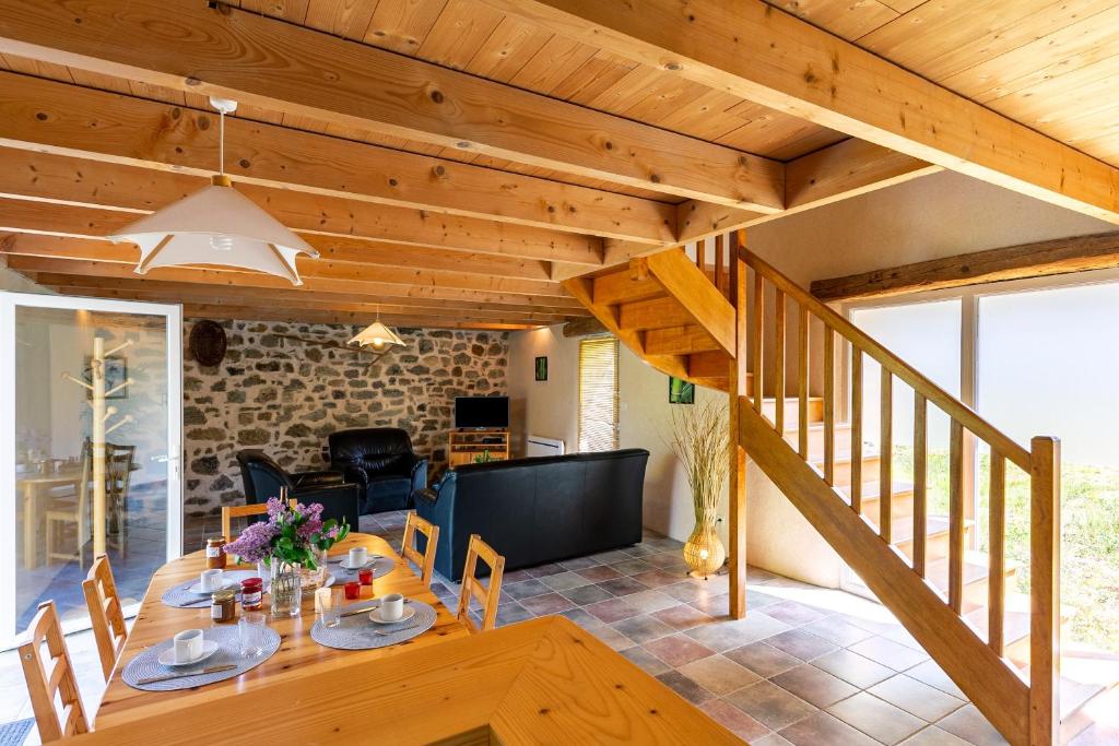 a dining room with a wooden table and a staircase at Ty Lann in Telgruc-sur-Mer