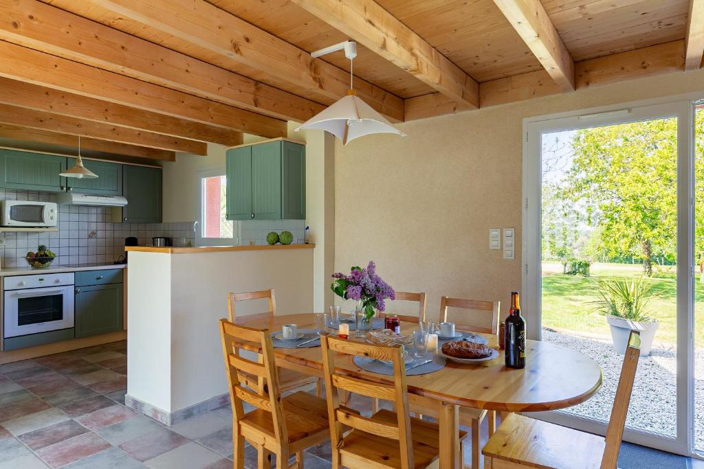 a kitchen and dining room with a wooden ceiling at Ty Lann in Telgruc-sur-Mer