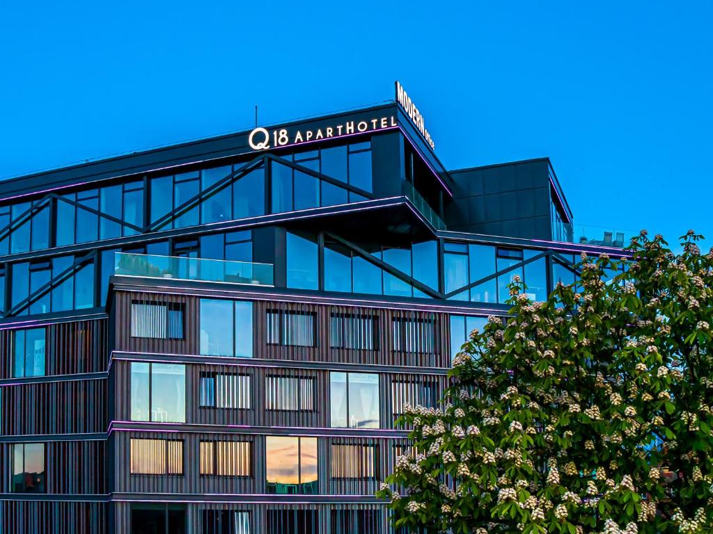 an office building with a sign on top of it at Q18 ApartHotel in Bydgoszcz