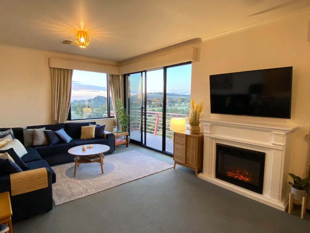 a living room with a fireplace and a tv at Wirrina Cove Apartment in Wirrina Cove