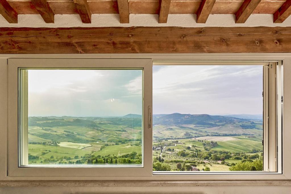 a window in a room with a view of the countryside at La finestra - centro storico Montepulciano, casa panoramica. in Montepulciano