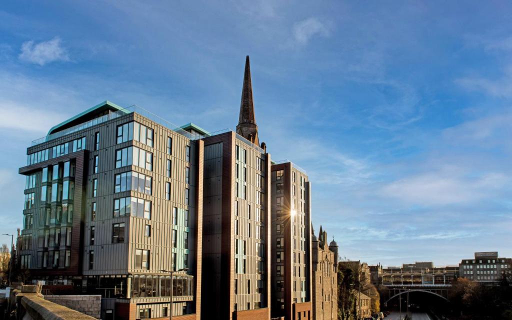 ein hohes Gebäude mit Kirchturm in einer Stadt in der Unterkunft Chic Apartments and Studios at The Point in Aberdeen in Aberdeen