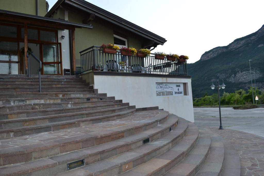 un edificio con escaleras y un balcón con flores. en GARNI ANNA en Besenello