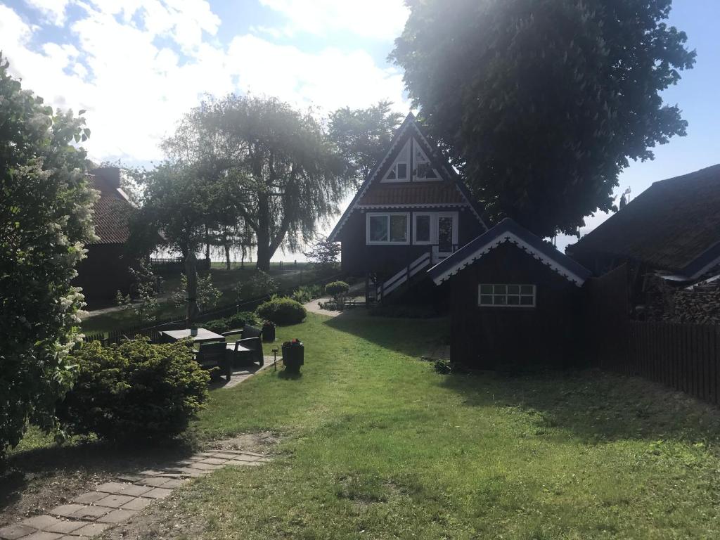 a house with a grass yard in front of it at Namelis ir marios in Nida