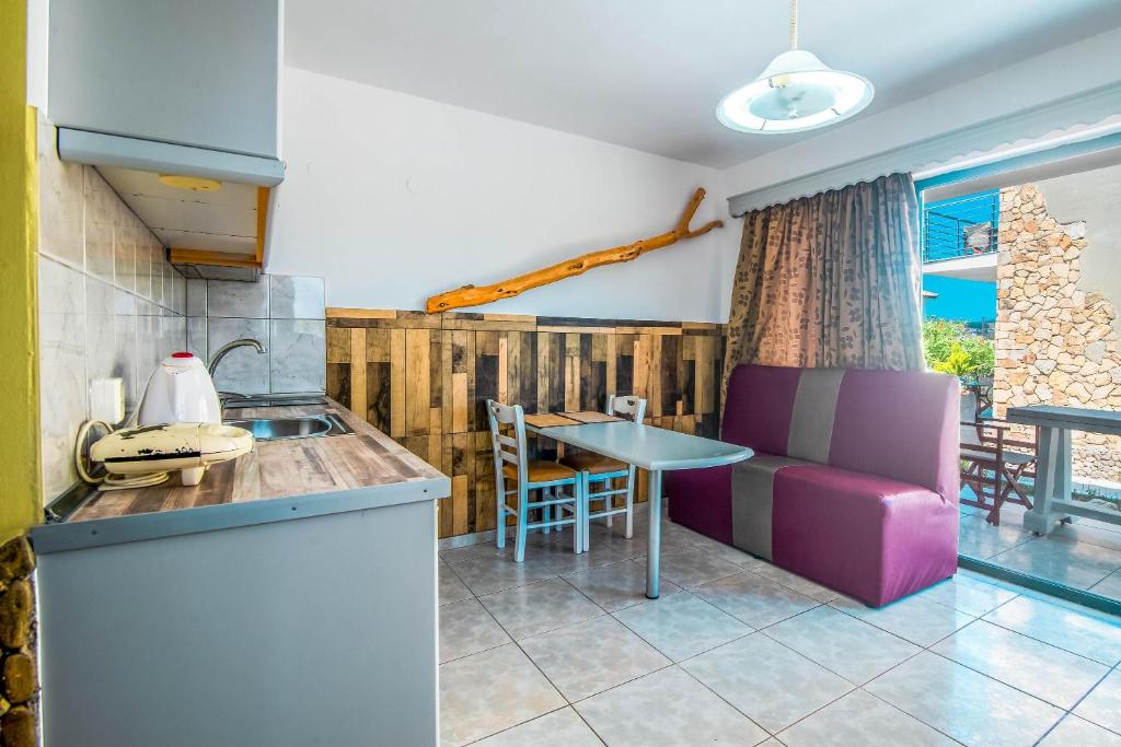 une cuisine avec une table et une chaise violette dans l'établissement Mirage Arillas Studio Type A9, à Arillas
