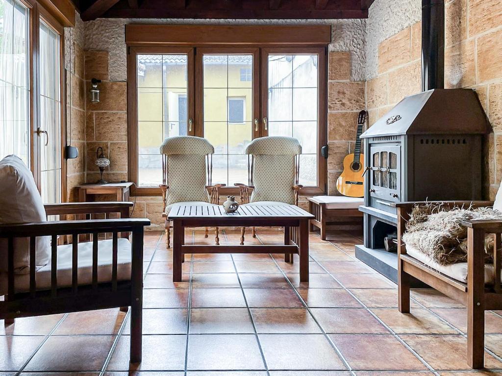 ein Wohnzimmer mit Stühlen und einem Holzofen in der Unterkunft Casa El Arrabal, casa con chimenea, piscina y patio in Medina de Ríoseco