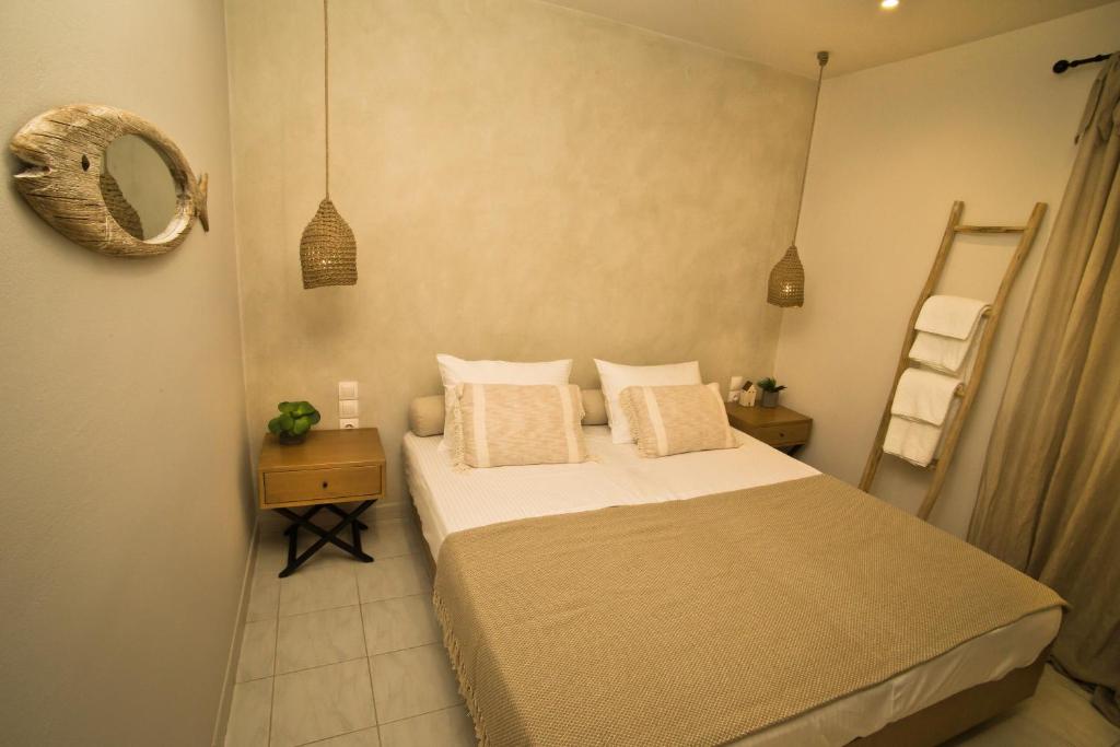 a small bedroom with a bed and a mirror at Horizon Hotel Kalymnos in Myrties