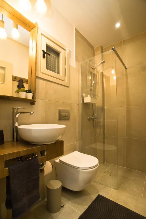a bathroom with a toilet and a sink and a shower at Horizon Hotel Kalymnos in Myrties