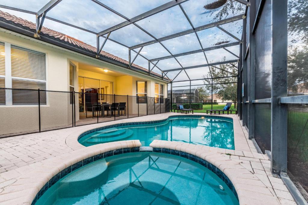 a swimming pool with a pergola next to a house at Spacious Home wPrivate PoolSpa & FREE Waterpark in Orlando